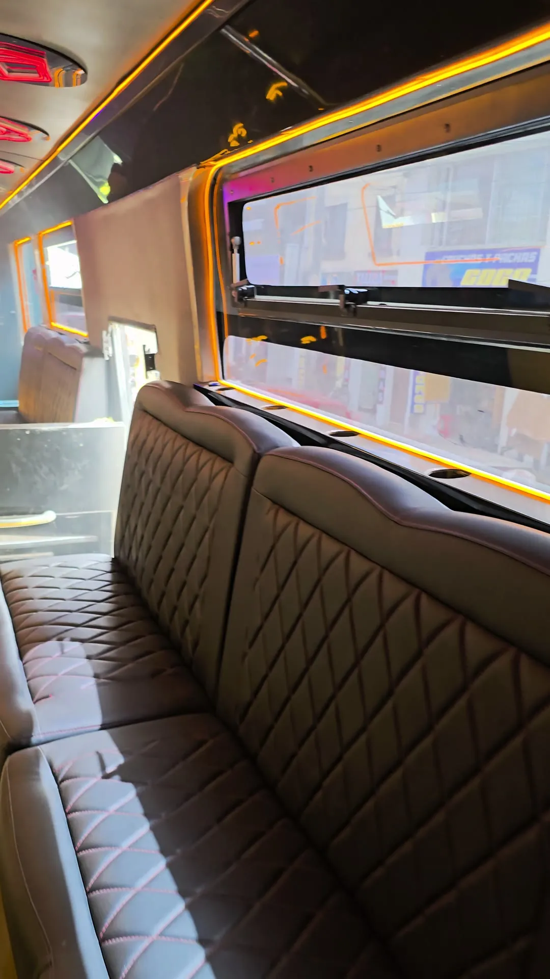 Sofás capitoneados y luz amarilla a lo largo de las ventanas del bus de Poker