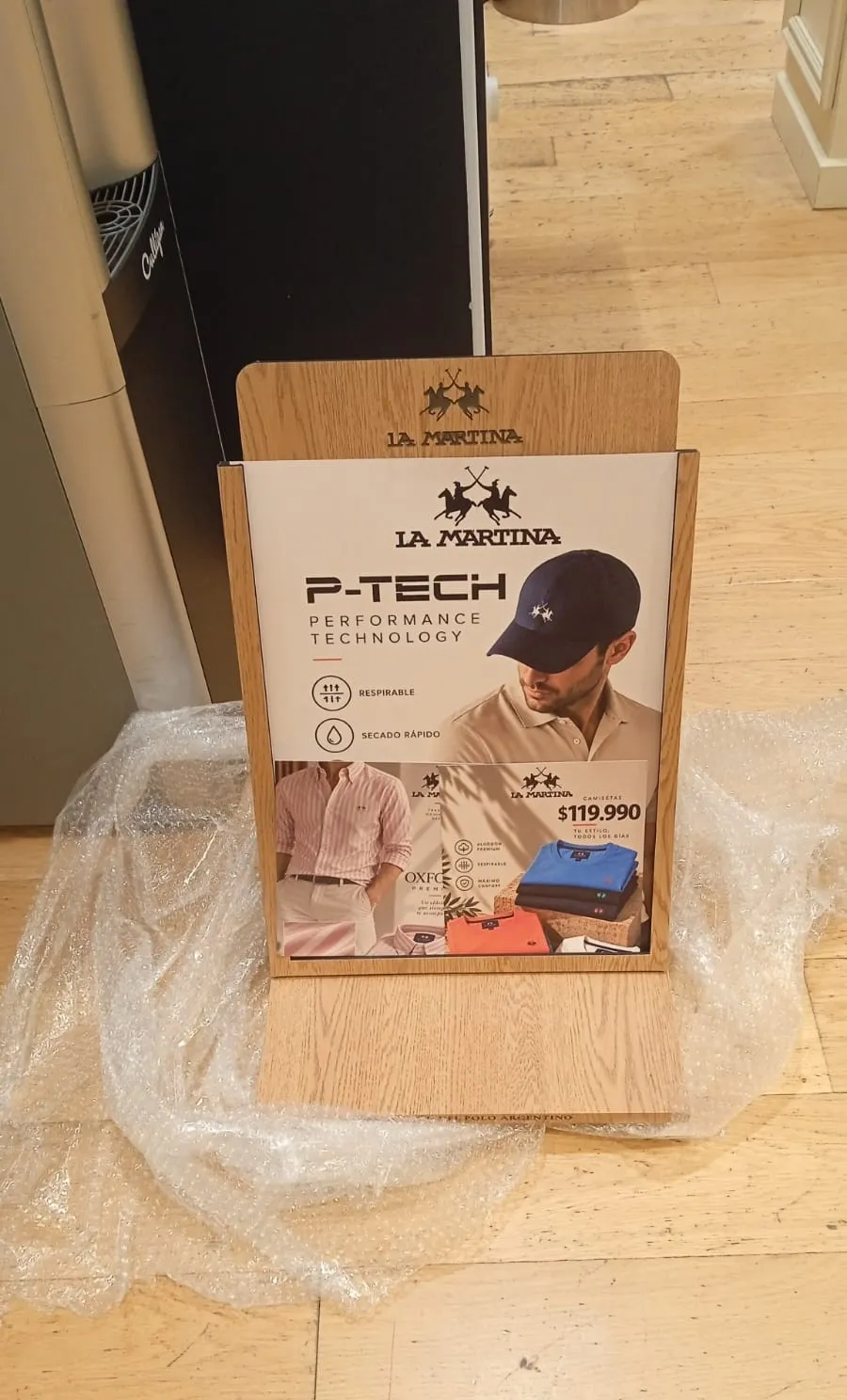 Display de mostrador de La Martina con afiche de P-Tech