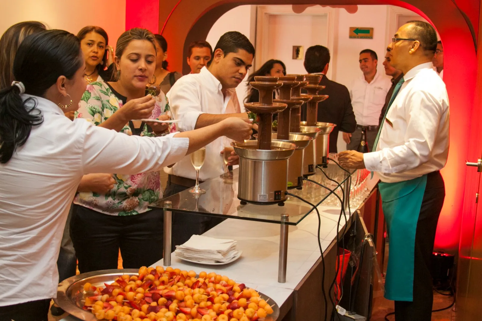 Asistentes en el evento frente a las fuentes de chocolate
