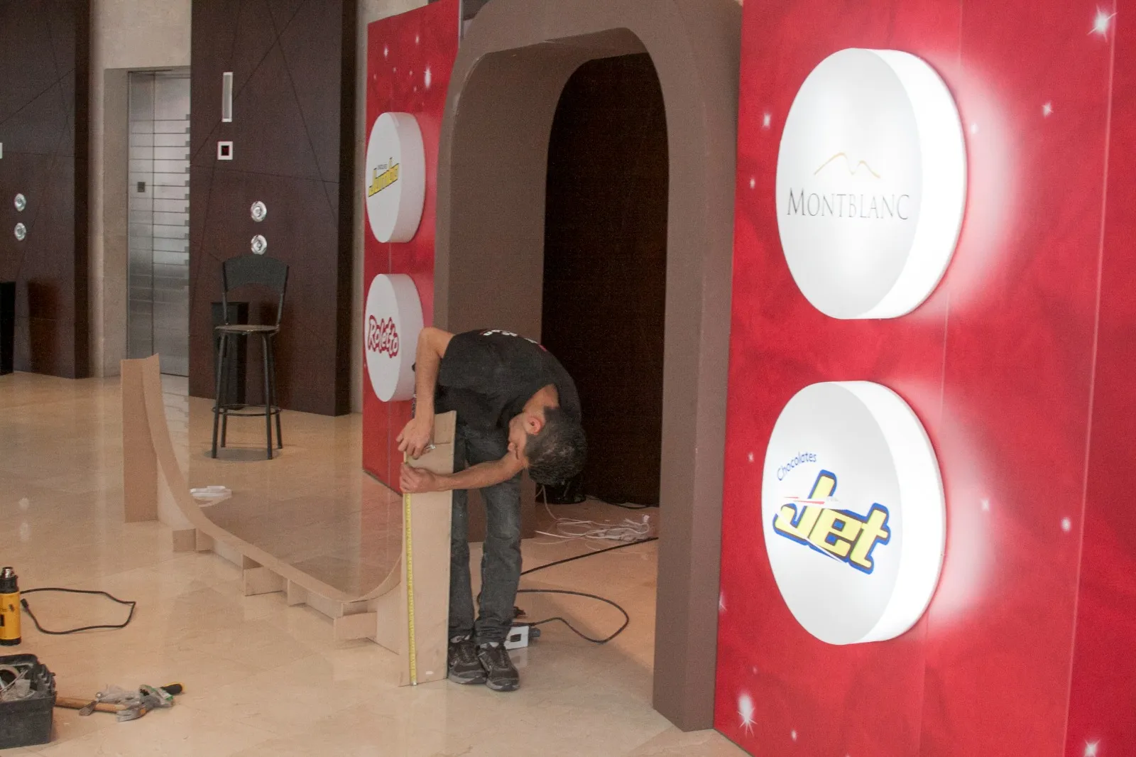 Instalador midiendo el arco de un stand antes del evento