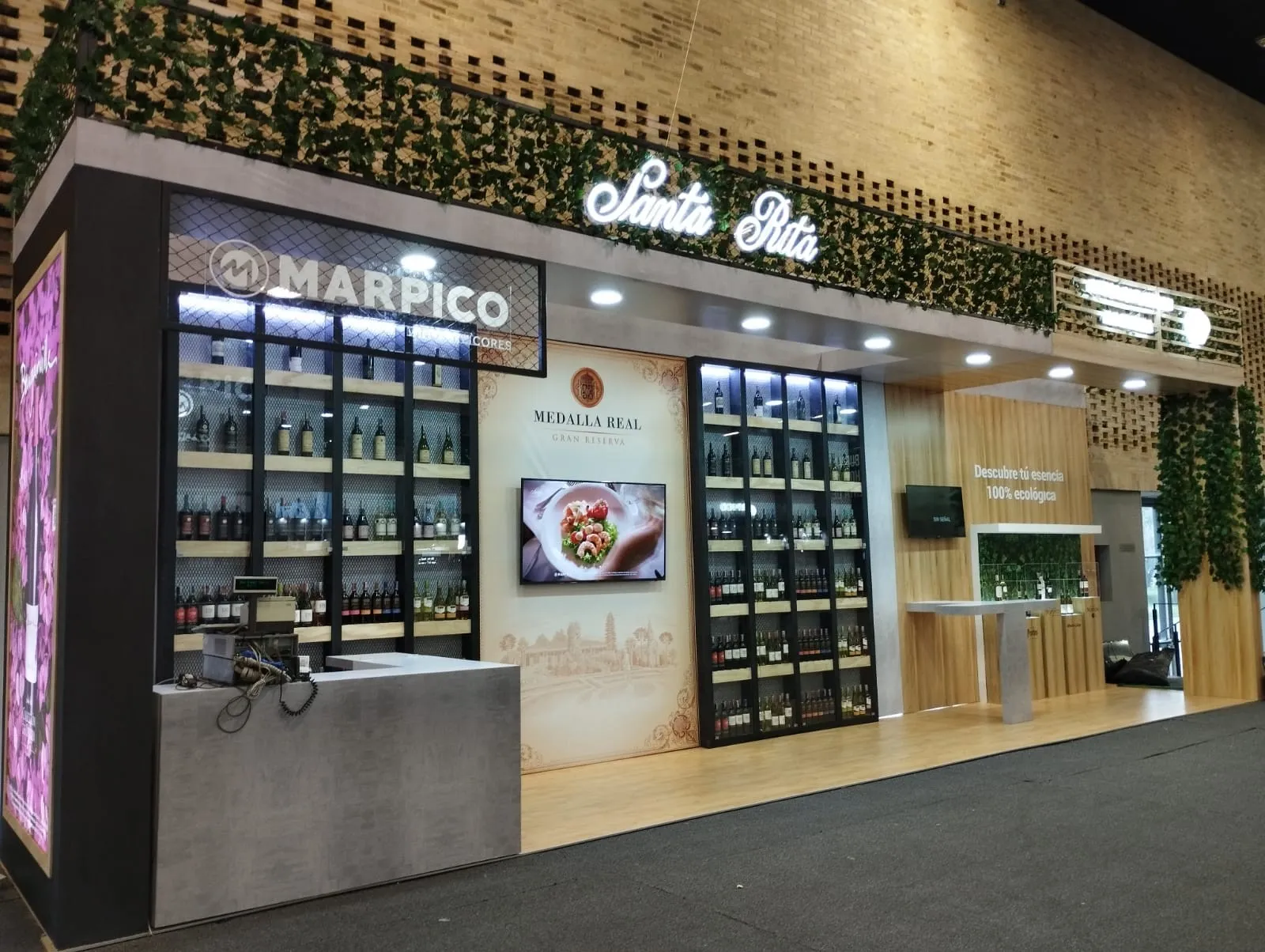 Stand de Marpico para vinos Santa Rita, con vitrinas de botellas iluminadas, mostrador y jardín vertical