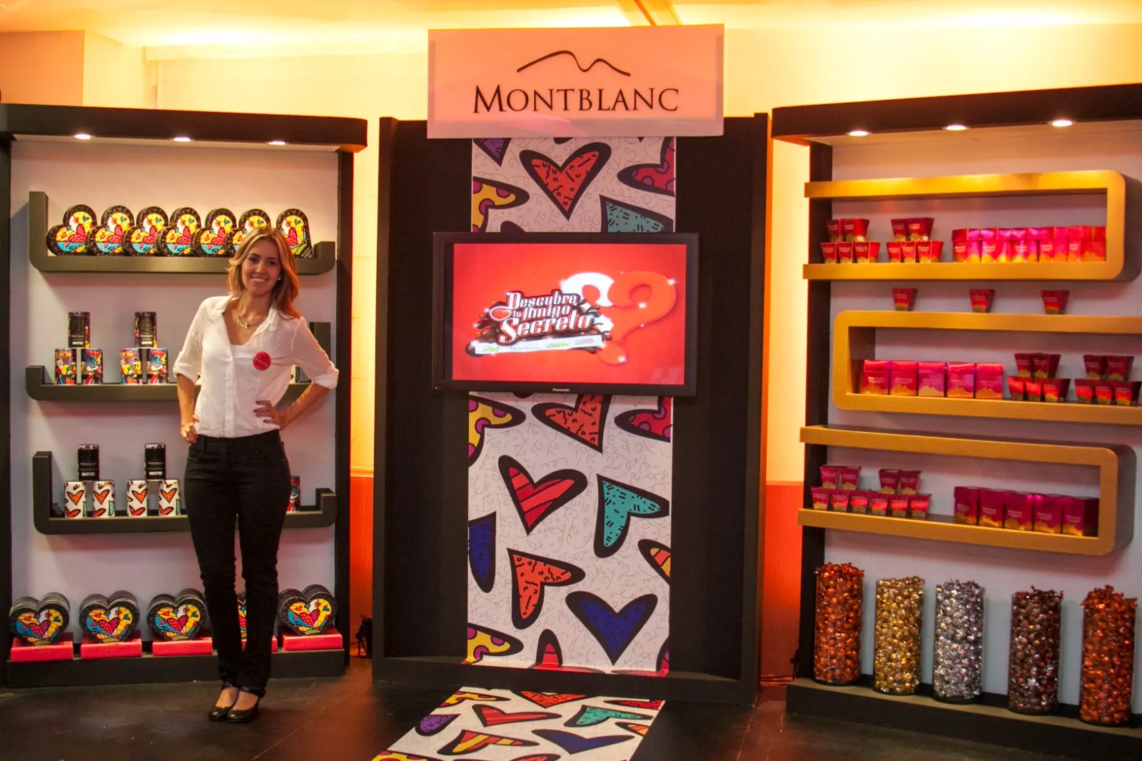 Stand de Montblanc con repisas doradas, pantalla y promotora
